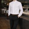 Hombre con pantalón negro elegante y camisa blanca en restaurante profesional
