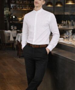 Hombre con pantalón negro elegante y camisa blanca en restaurante profesional