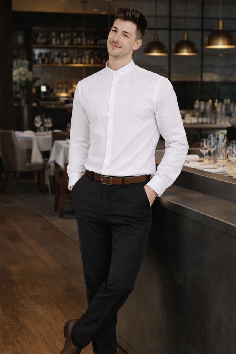 Hombre con pantalón negro elegante y camisa blanca en restaurante profesional
