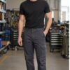 Hombre con pantalón de trabajo gris Velilla Arrow 4-Xtreme slim fit elástico en entorno profesional