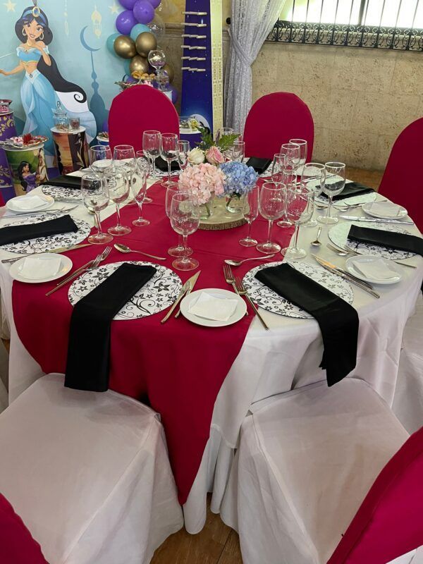 Mesa decorada con mantelería burdeos y blanca para fiesta temática de la princesa Jazmín