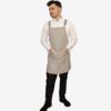 Delantal tipo peto elegante en tejido falso liso 100% poliéster, ideal para profesionales de hostelería y cocina.