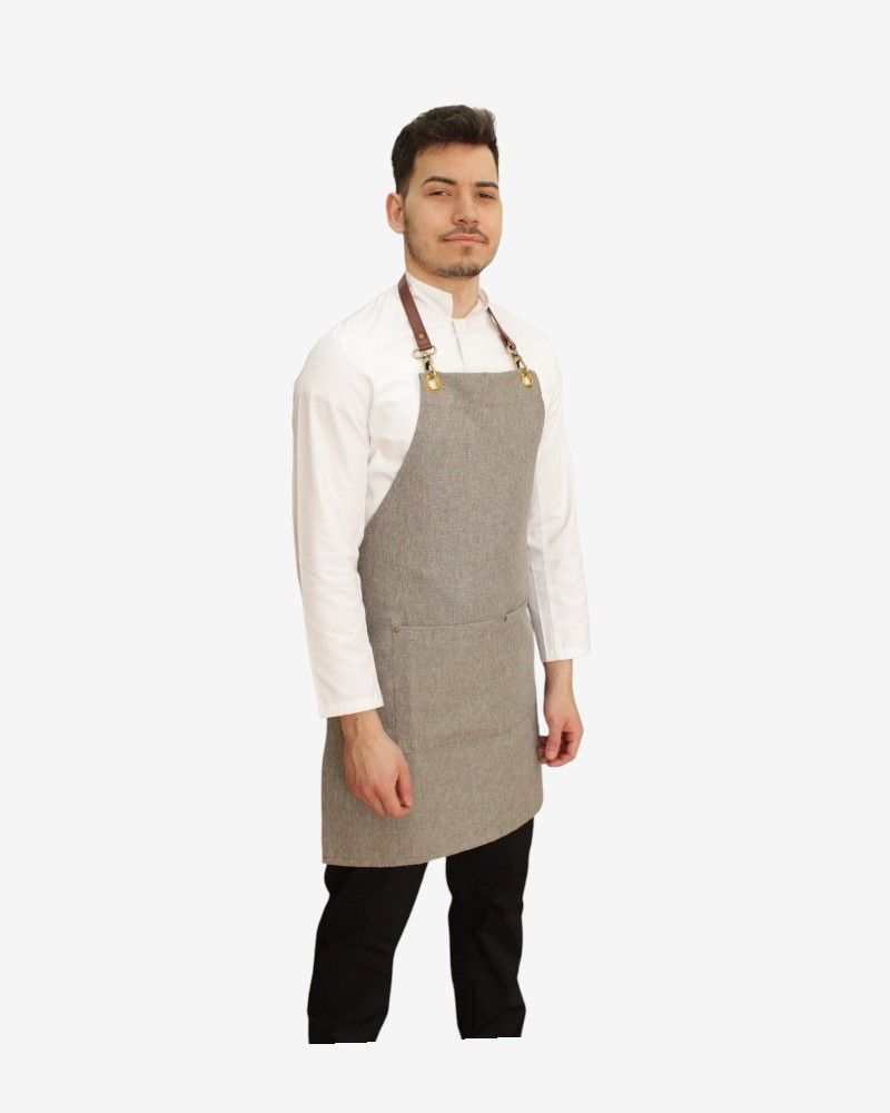 Delantal tipo peto elegante en tejido falso liso 100% poliéster, ideal para profesionales de hostelería y cocina.