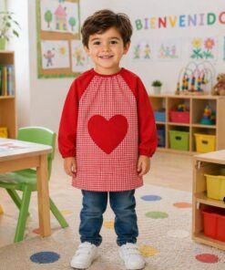Niño con babero infantil vichy corazón rojo en colegio protegiendo la ropa durante actividades escolares