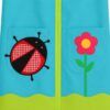 Bata de maestra personalizada en Popelín Galaxy color turquesa con apliques de tela de mariquita y flor sobre los bolsillos