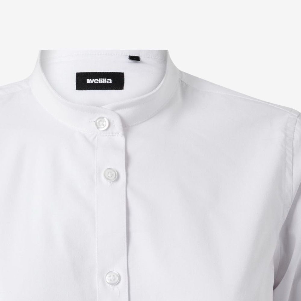 Detalle frontal de camisa blanca con cuello mao y cierre de botones, marca Velilla